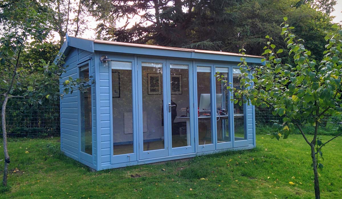 A photo of a blue shed in a green garden